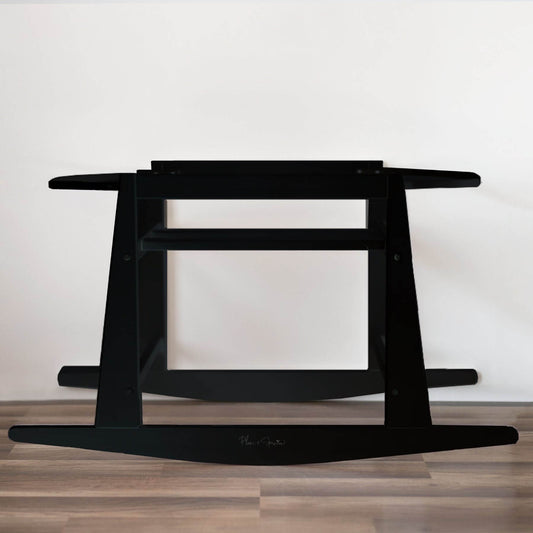 Plum+Sparrow Original Rocking Moses Bassinet Stand with brake Black on a wooden floor with a white wall background