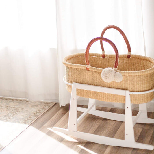 Wicker Moses basket on Plum+Sparrow Original Rocking Moses Bassinet Stand with brake White with light-colored floor and walls.