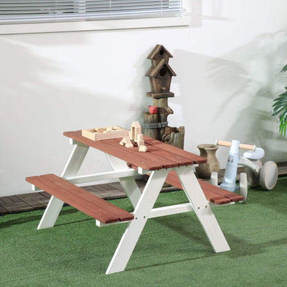 Wooden picnic table with benches on a green surface, with toys and a birdhouse in the background.