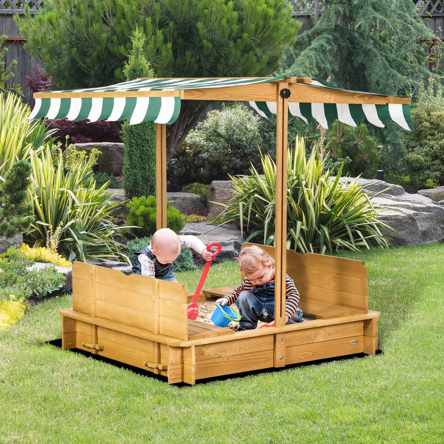 Children playing in a wooden sandbox with canopy in a garden setting