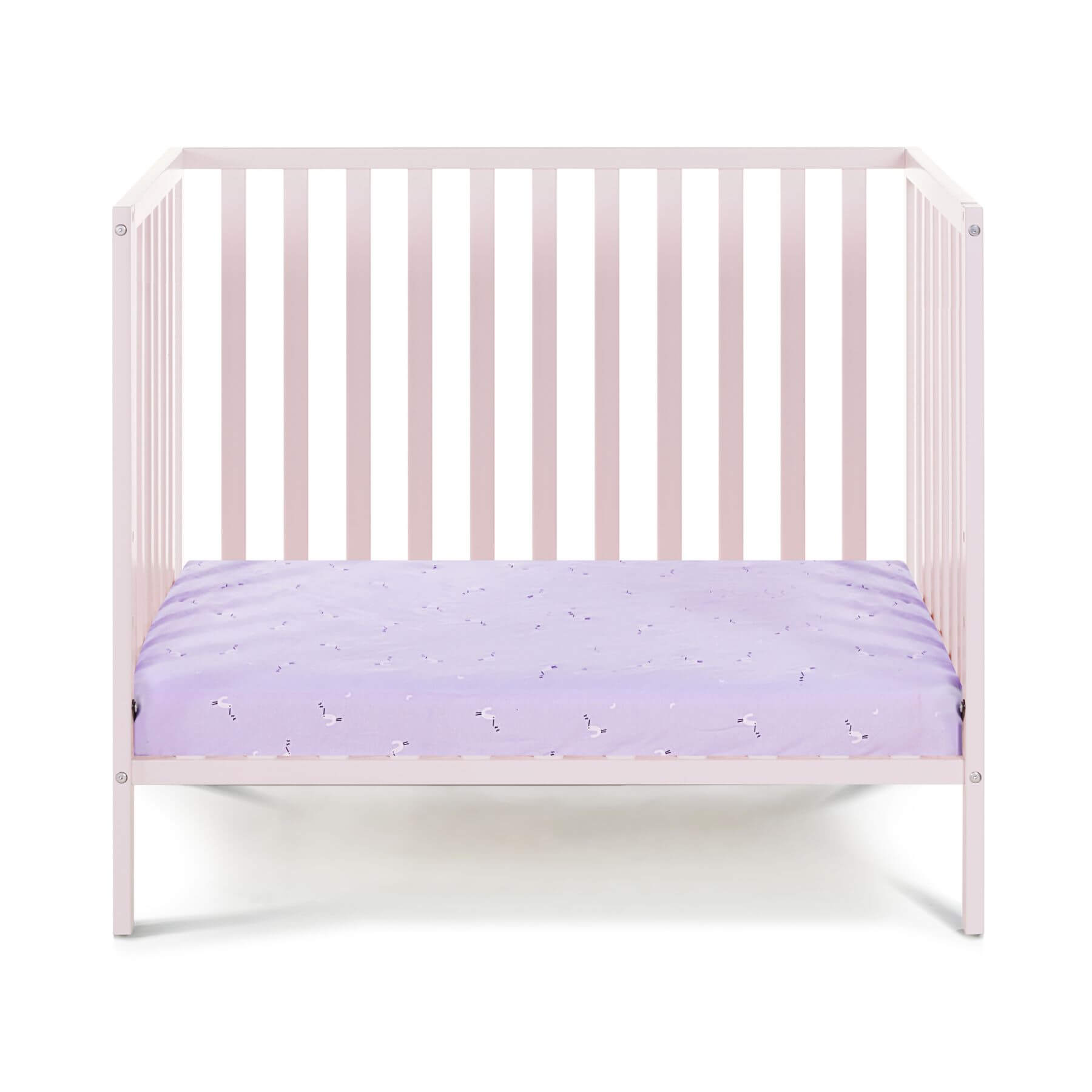 Pink crib with a purple mattress on a white background