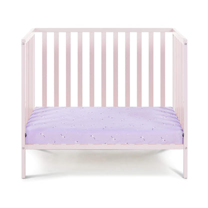 Pink crib with a purple mattress on a white background