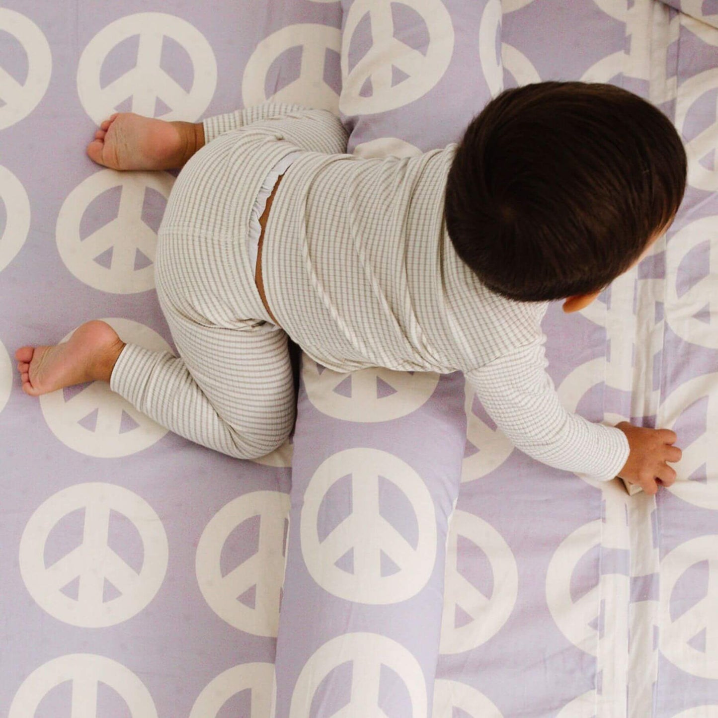 Child crawling on Toki Kids Peace Sign Organic Cotton Mat