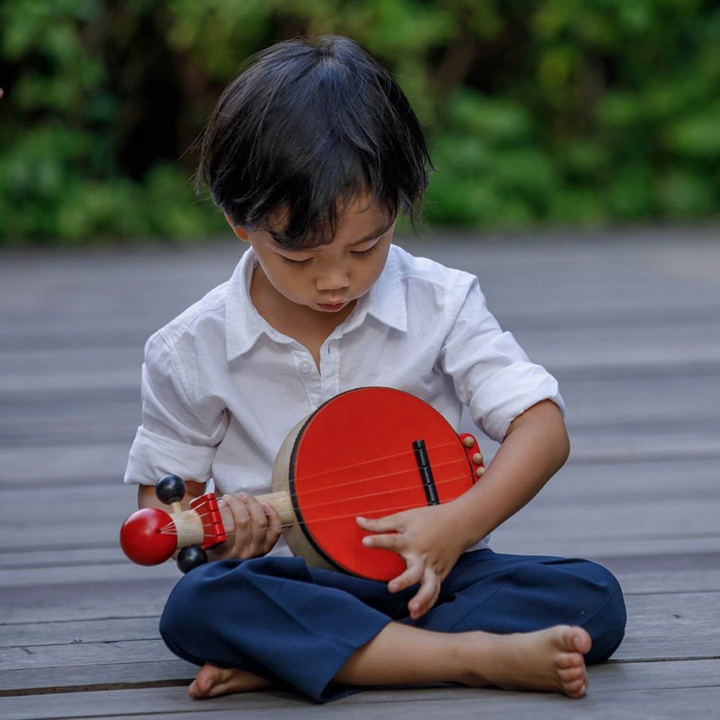 Boy Playing PlanToys Banjo