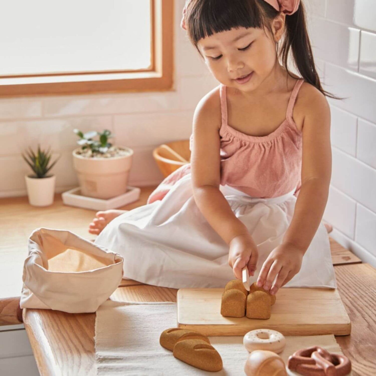 Girl Playing PlanToys Bread Set