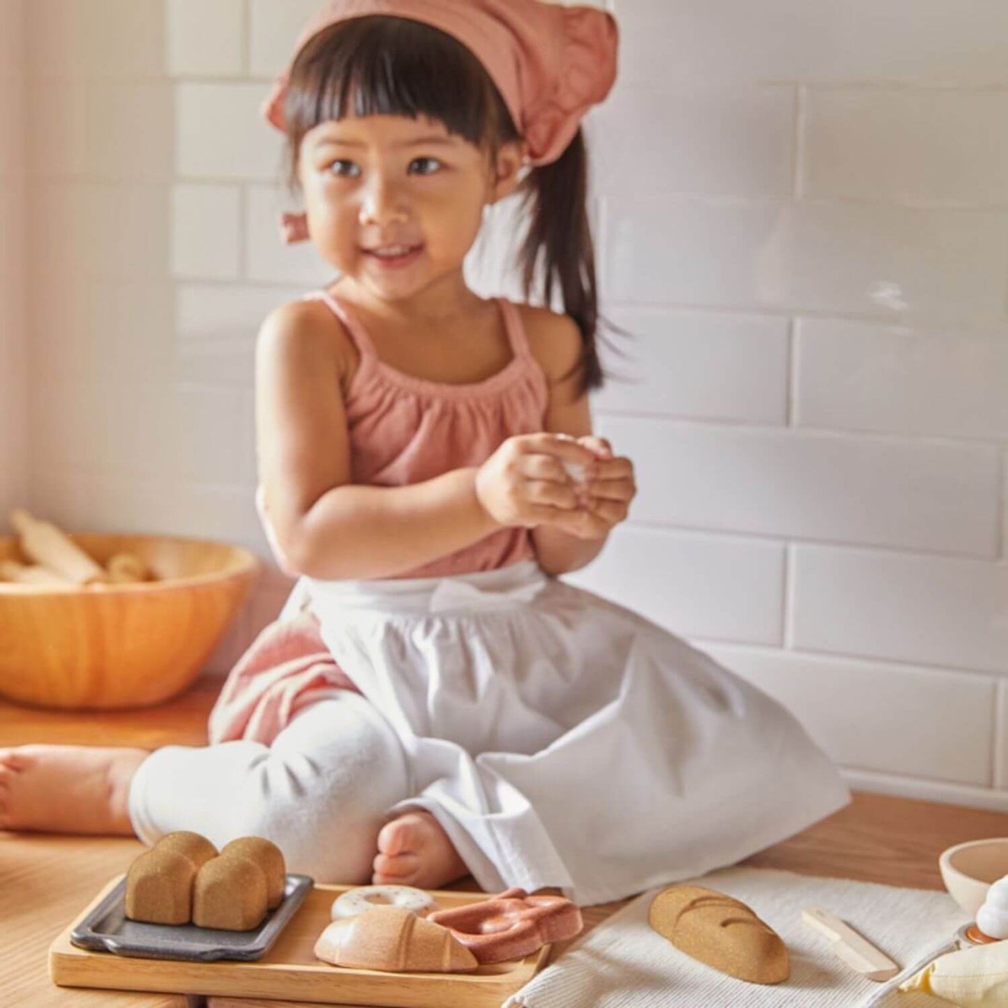 Girl Playing PlanToys Bread Set