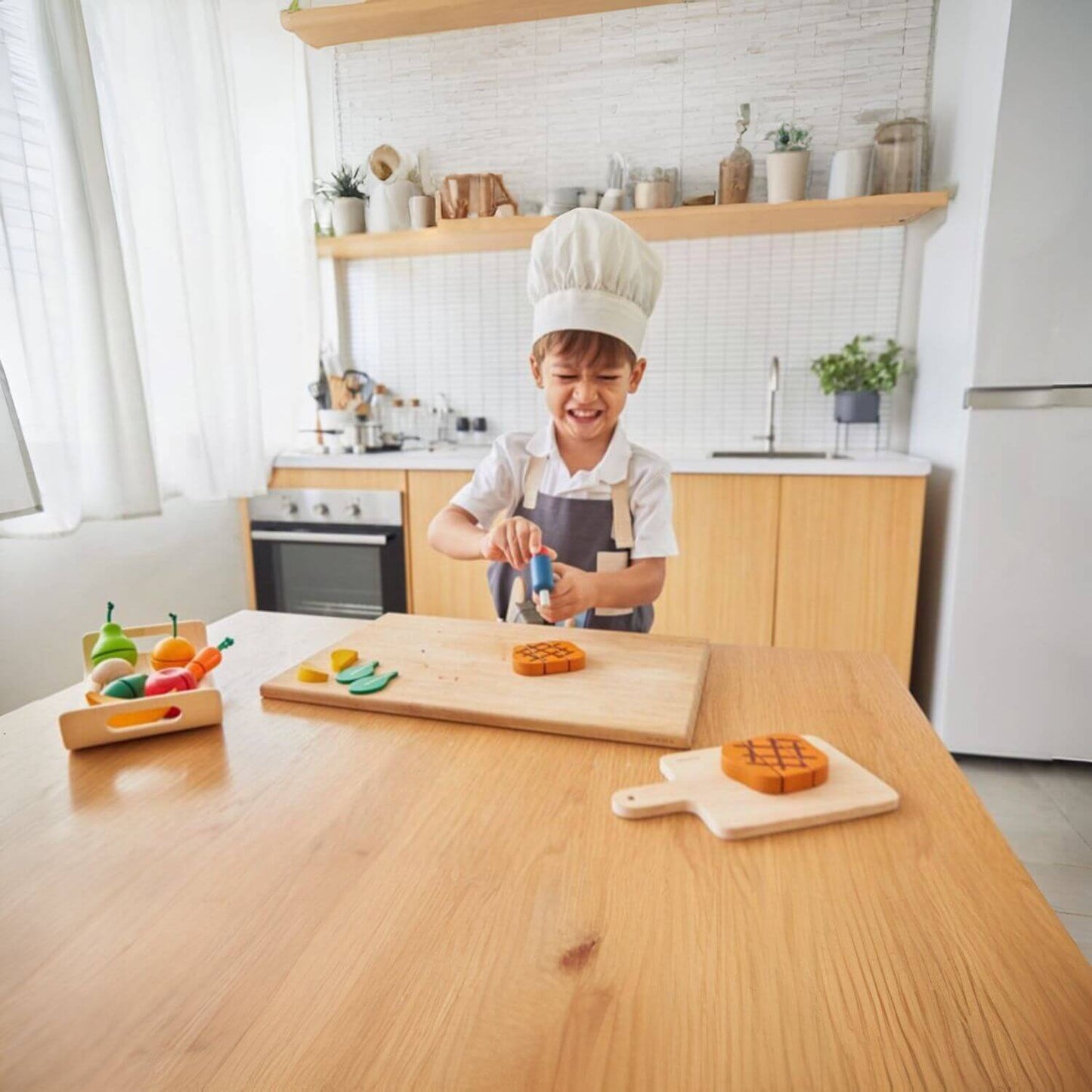 Boy Wearing PlanToys Chef Set to Cook