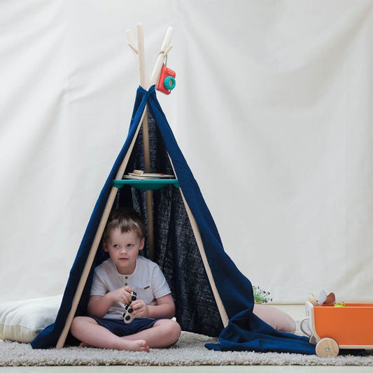 Boy Sitting Under PlanToys Coat Rack