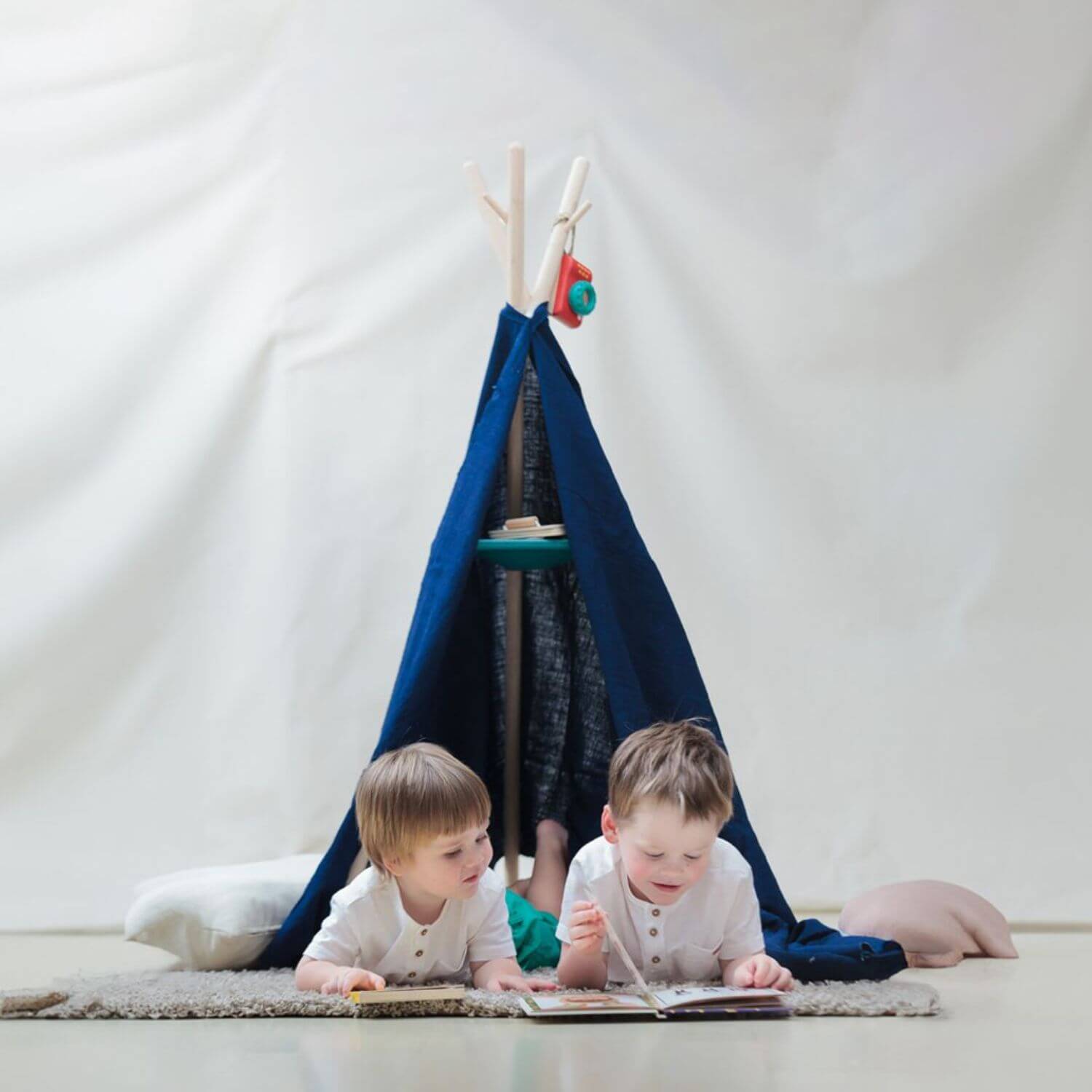 Kids Reading next to PlanToys Coat Rack