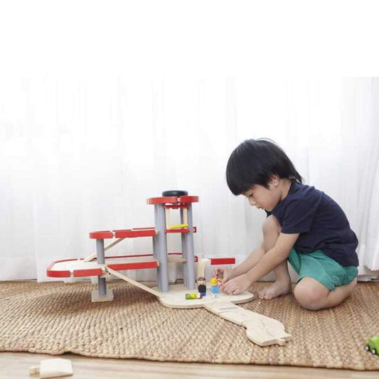 Child playing with PlanToys Parking Garage on a mat