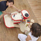 Two children playing with PlanToys Parking Garage on a wooden floor.