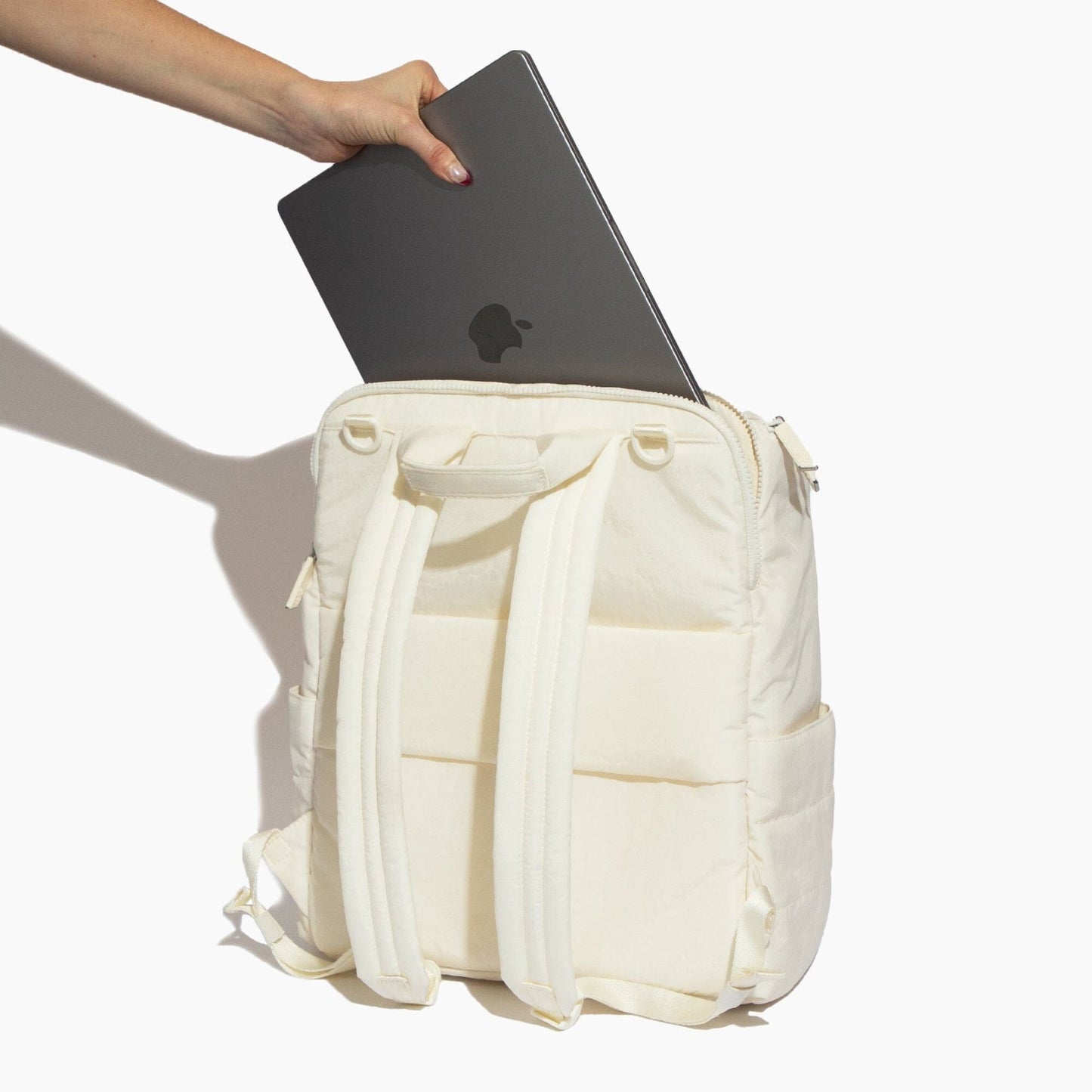Polar Zurich Diaper Bag with a laptop being placed into it on a white background