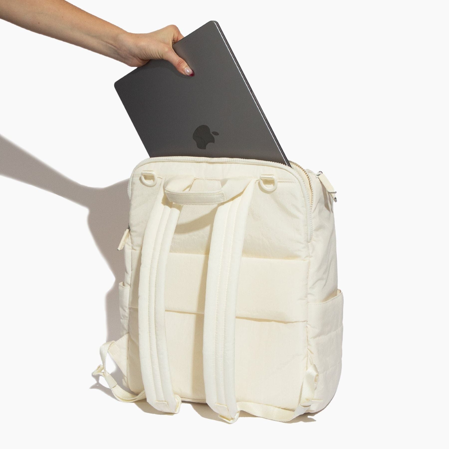 Polar Zurich Diaper Bag with a laptop being placed into it on a white background