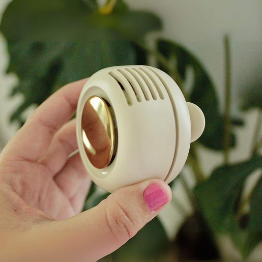Coco Carriers Portable Rechargeable Fan - Cream held by a hand