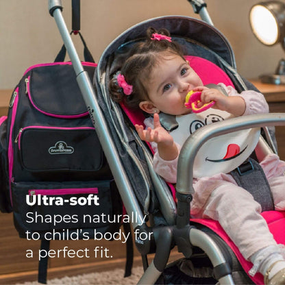A baby in a stroller with a matching backpack by Cribology, shown in a home setting with a text overlay highlighting the ultra-soft shapeability of the stroller liner.