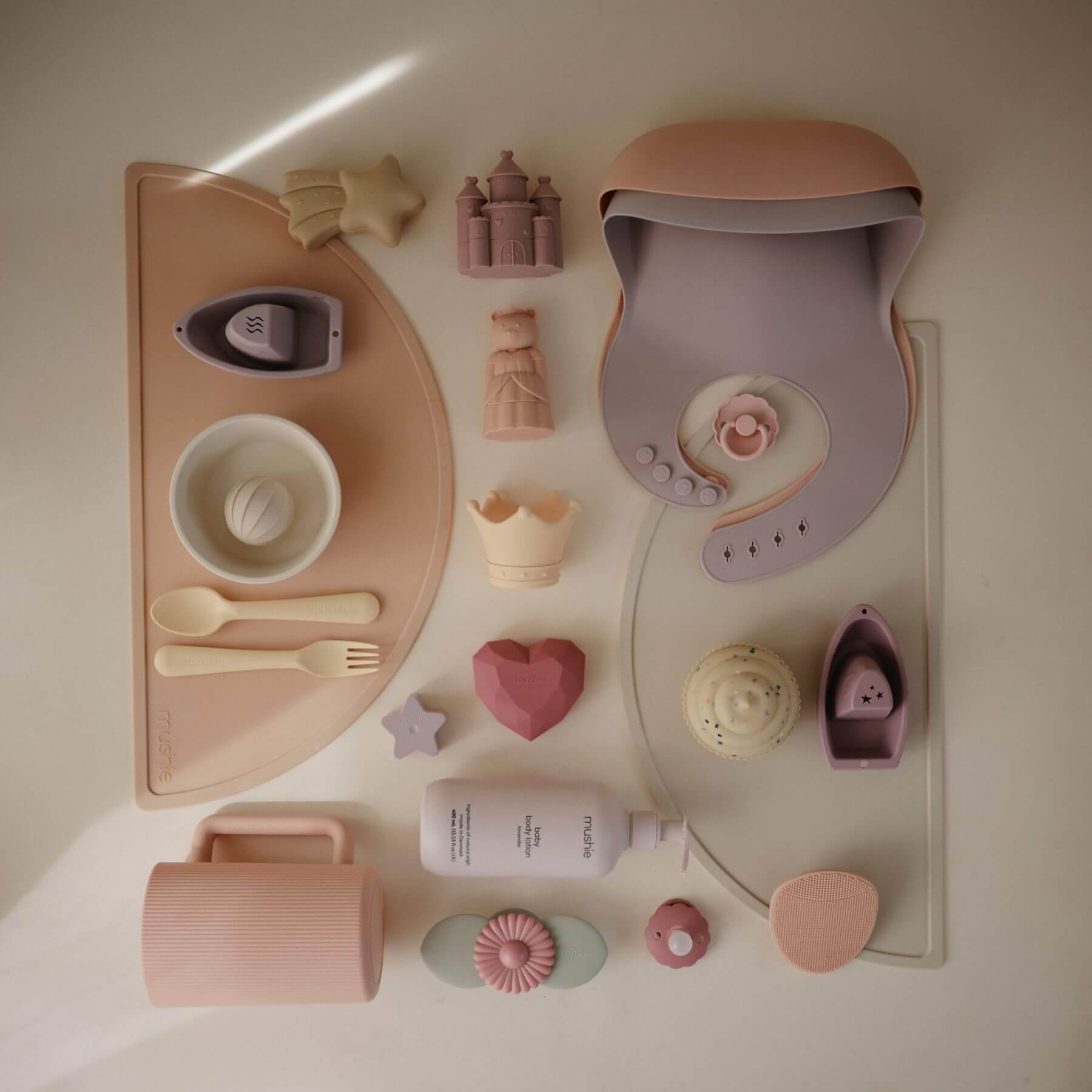 Collection of baby toys and items on a white surface