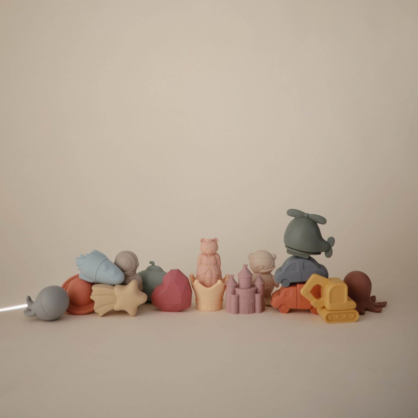 Row of colorful toy figures on a beige background