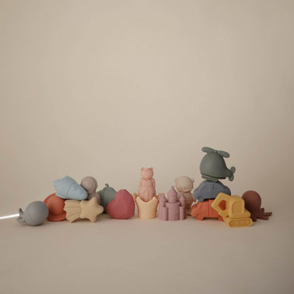 Row of colorful toy figures on a beige background