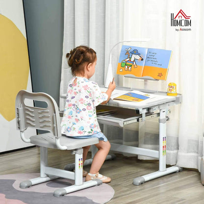 Child sitting at Qaba Kids Desk and Chair Set with USB Light, Storage Drawer Grey reading a book.