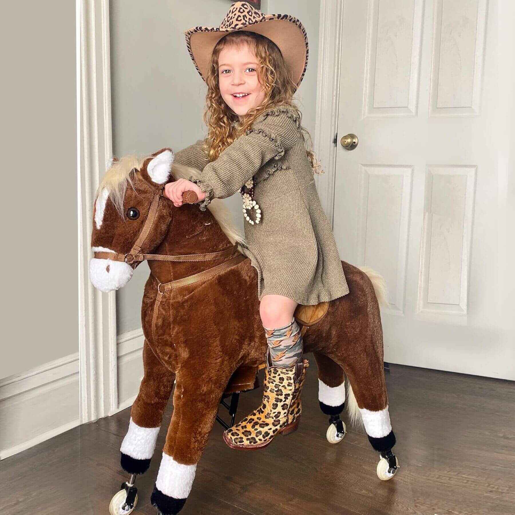 Child riding Qaba Kids Ride-on Walking Horse with Easy Rolling Wheels Brown in a room with a neutral color scheme.