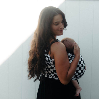 Woman holding a baby wrapped in Little Mae & Co Race Ring Sling Carrier