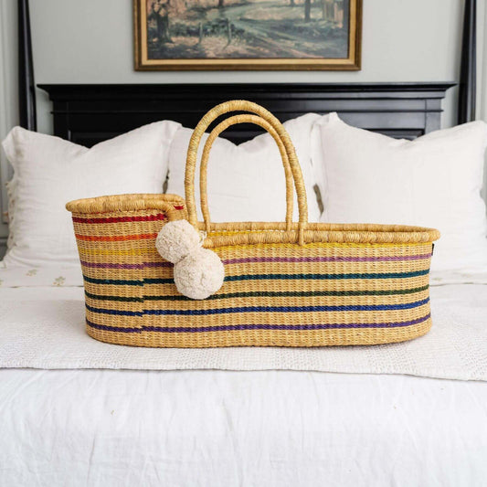 Plum+Sparrow Rainbow African Moses Basket Vegan Handle on a bed