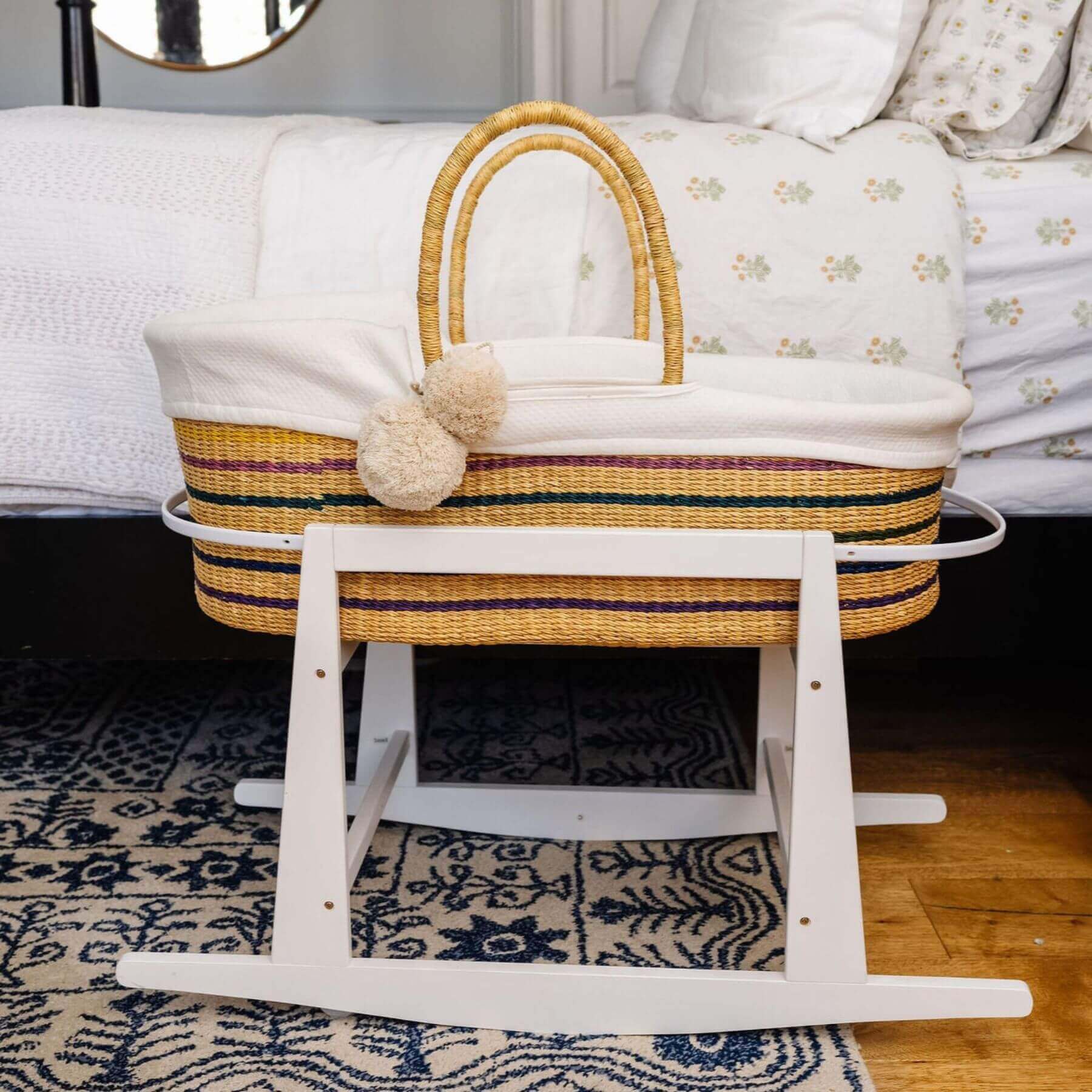 Plum+Sparrow Rainbow African Moses Basket Vegan Handle on a stand in a bedroom setting.