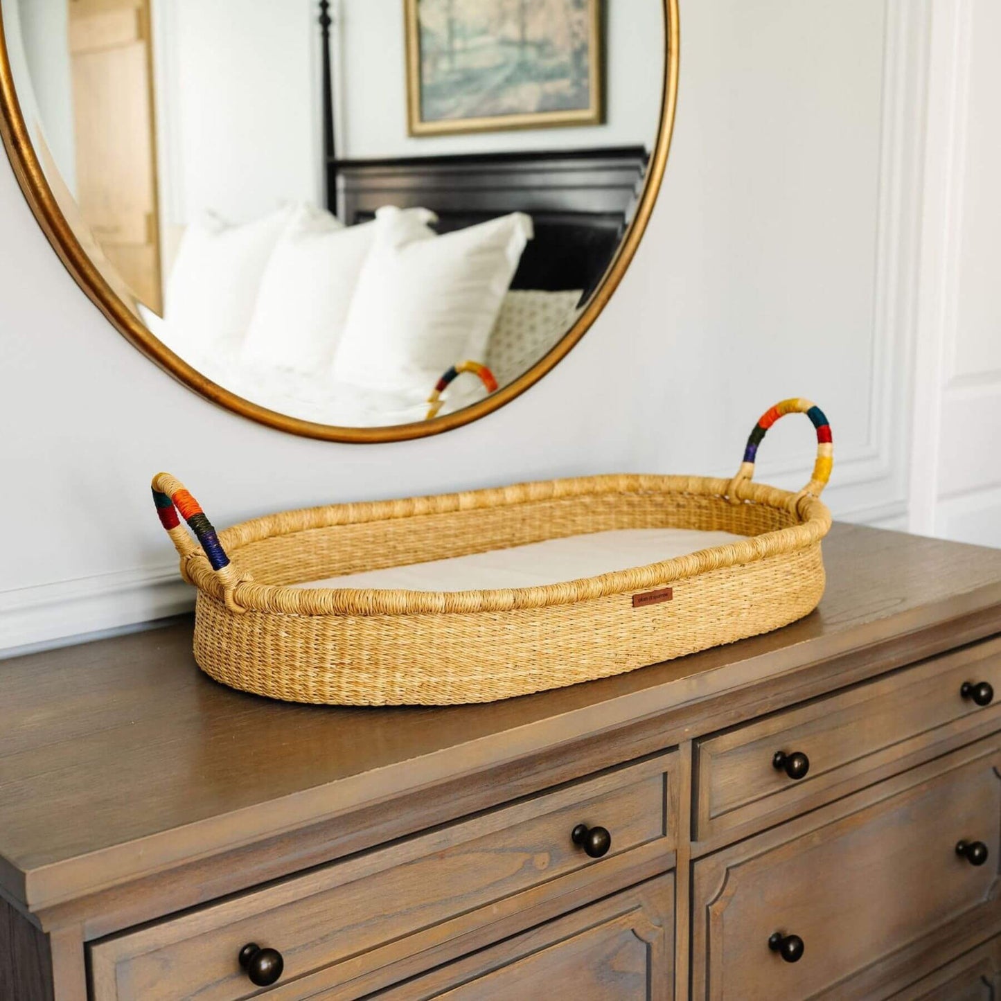 Plum+Sparrow Rainbow Handle Changing Basket on a wooden dresser