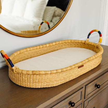 Plum+Sparrow Rainbow Handle Changing Basket on a wooden dresser