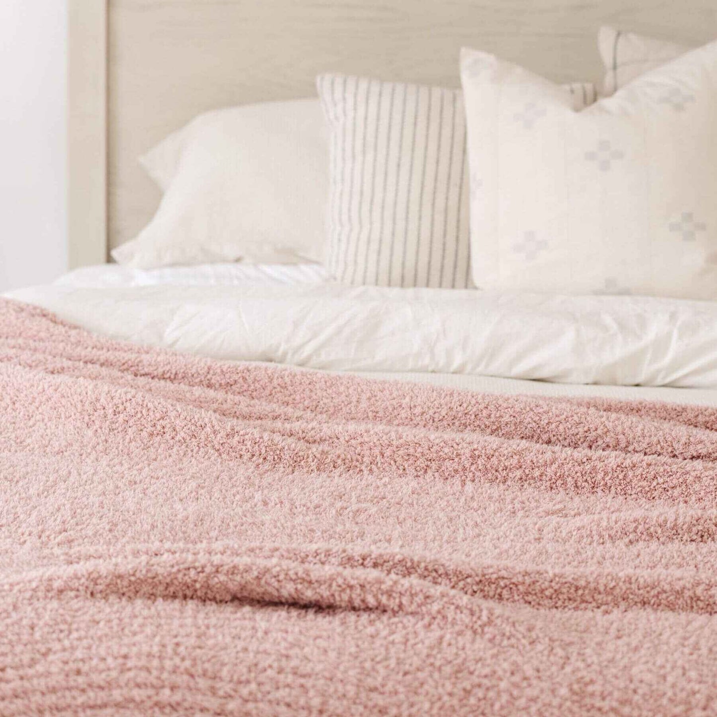 Bed with Saranoni Ribbed Bamboni® XL Blanket - Cameo and white pillows in a bedroom setting
