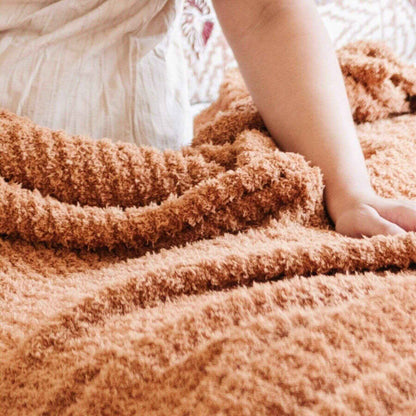 Close-up of Saranoni Ribbed Bamboni® XL Blanket - Gingerket with a blurred background