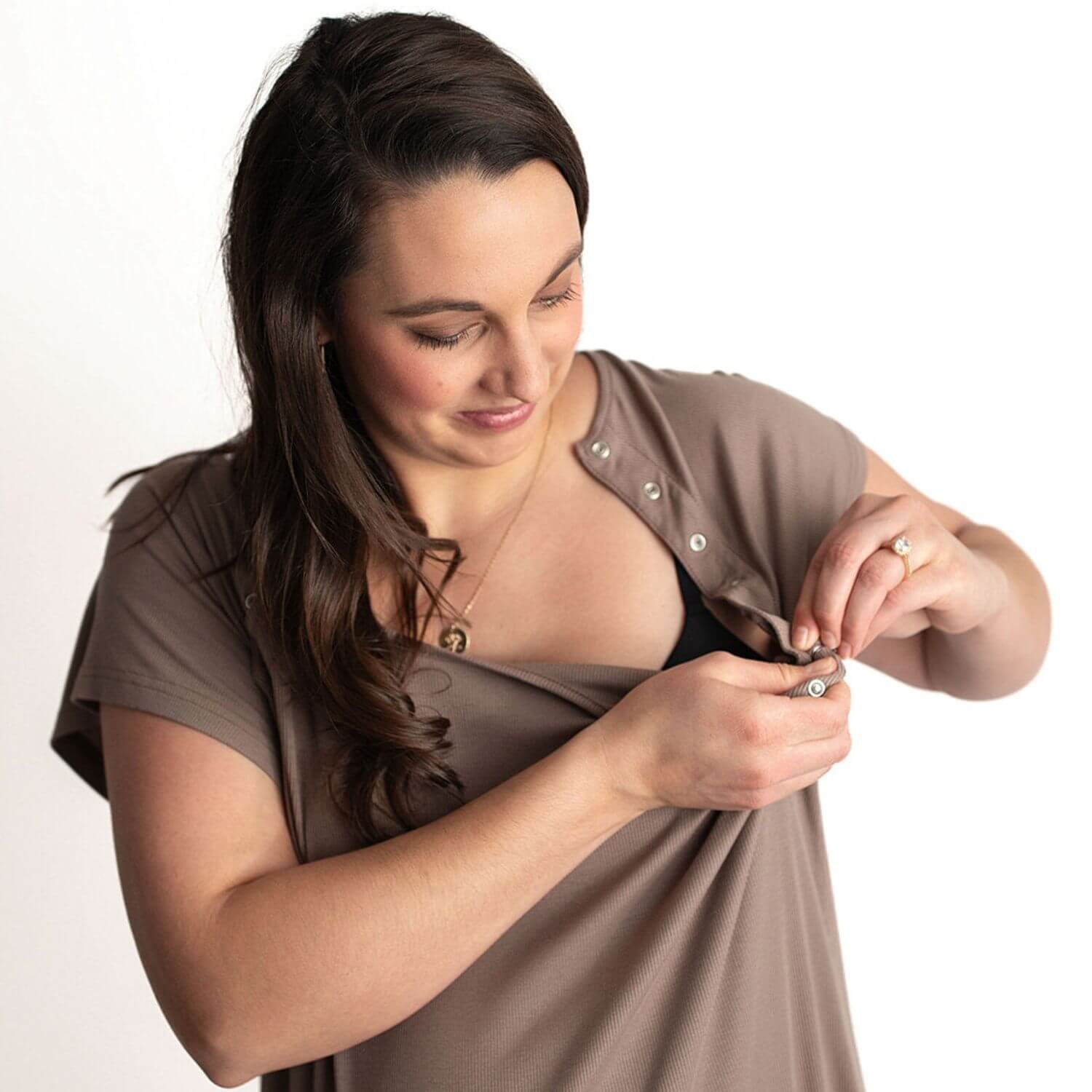 A woman with long dark brown hair is wearing Three Little Tots Ribbed Cocoa Brown Mommy Gown, lifting the shirt to show the undergarment.