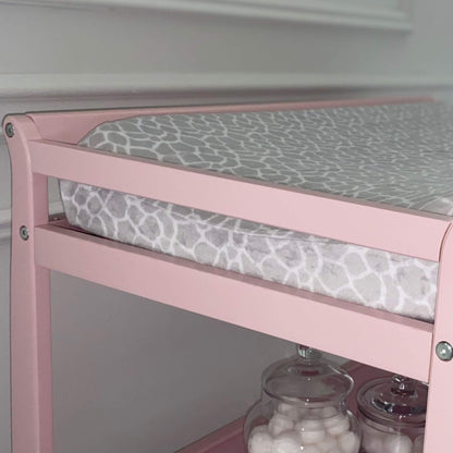 Riley Changing Table Pink with a gray patterned cushion on a white background