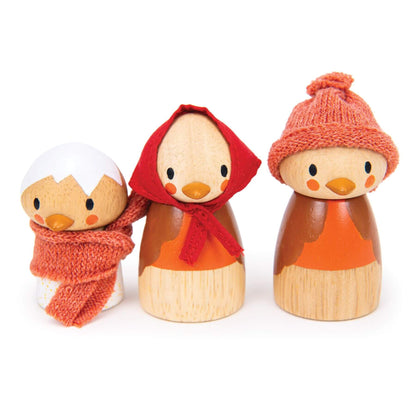 Three wooden ducklings with autumn-themed accessories on a white background