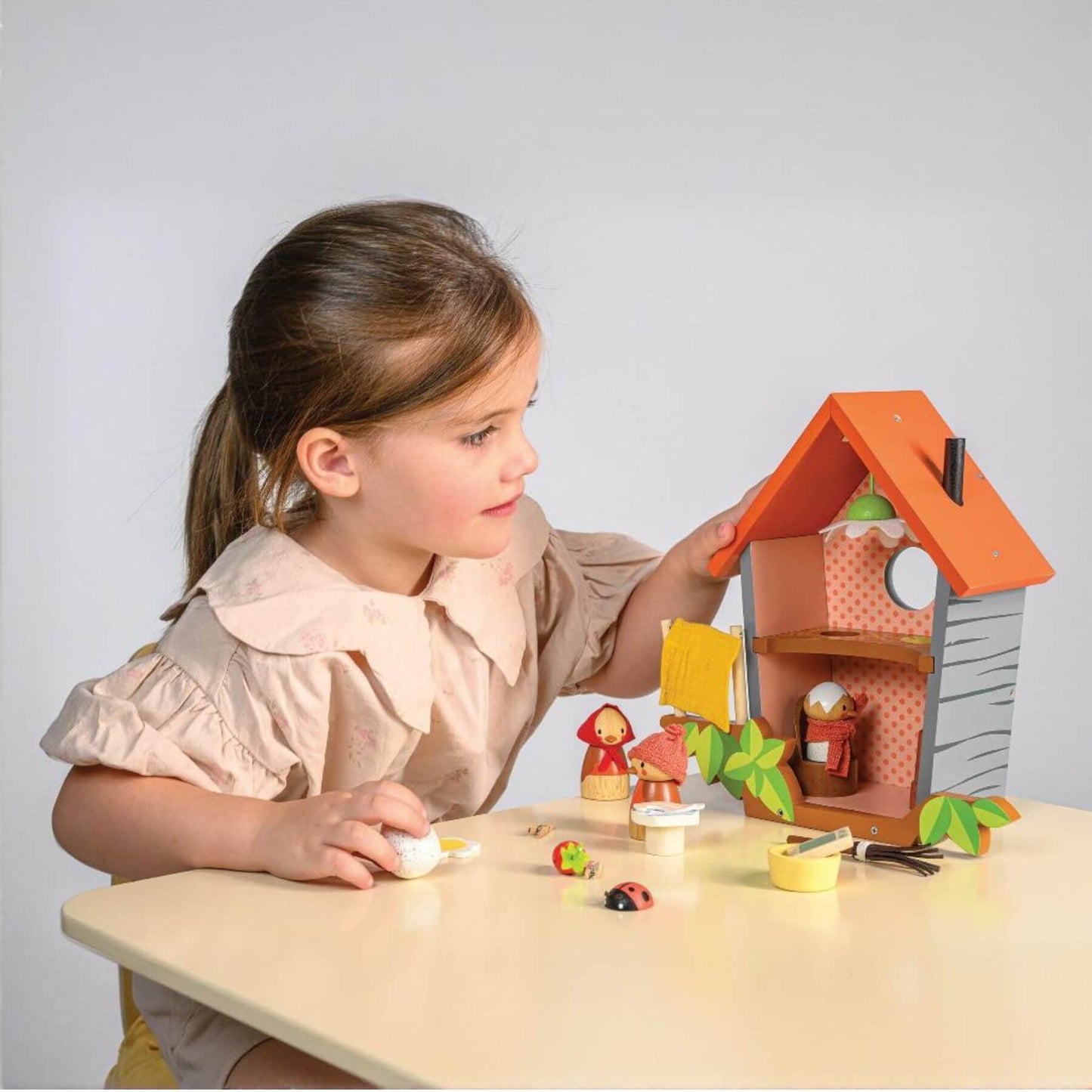 Child playing with Tender Leaf Robin's Nest Box on a table