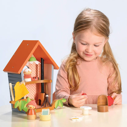 Young girl playing with Tender Leaf Robin's Nest Box on a light blue background