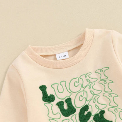 Beige sweatshirt with green 'Lucky' text on a beige background