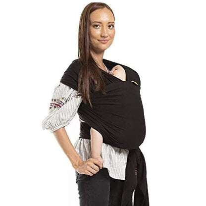 Woman wearing a black baby carrier on a white background