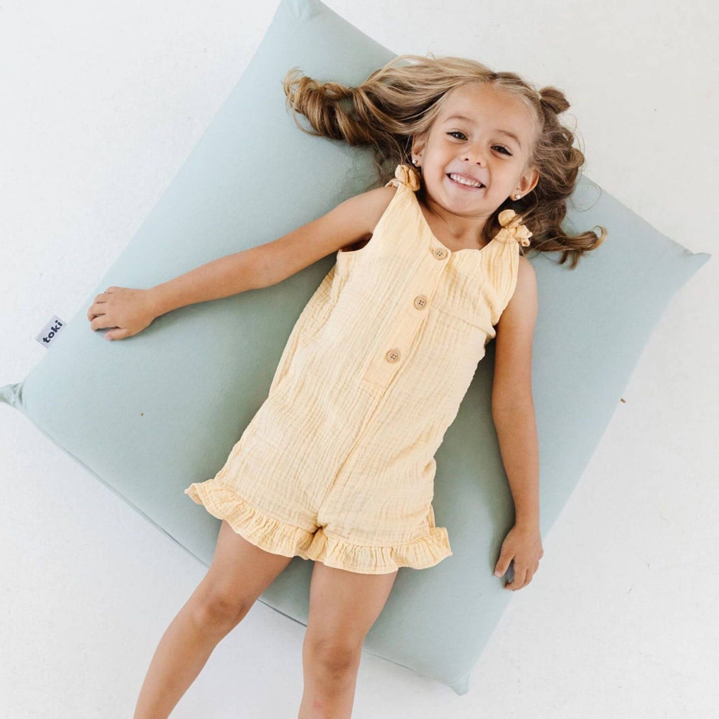 Young girl lying on Toki Kids Sage Bean Bag