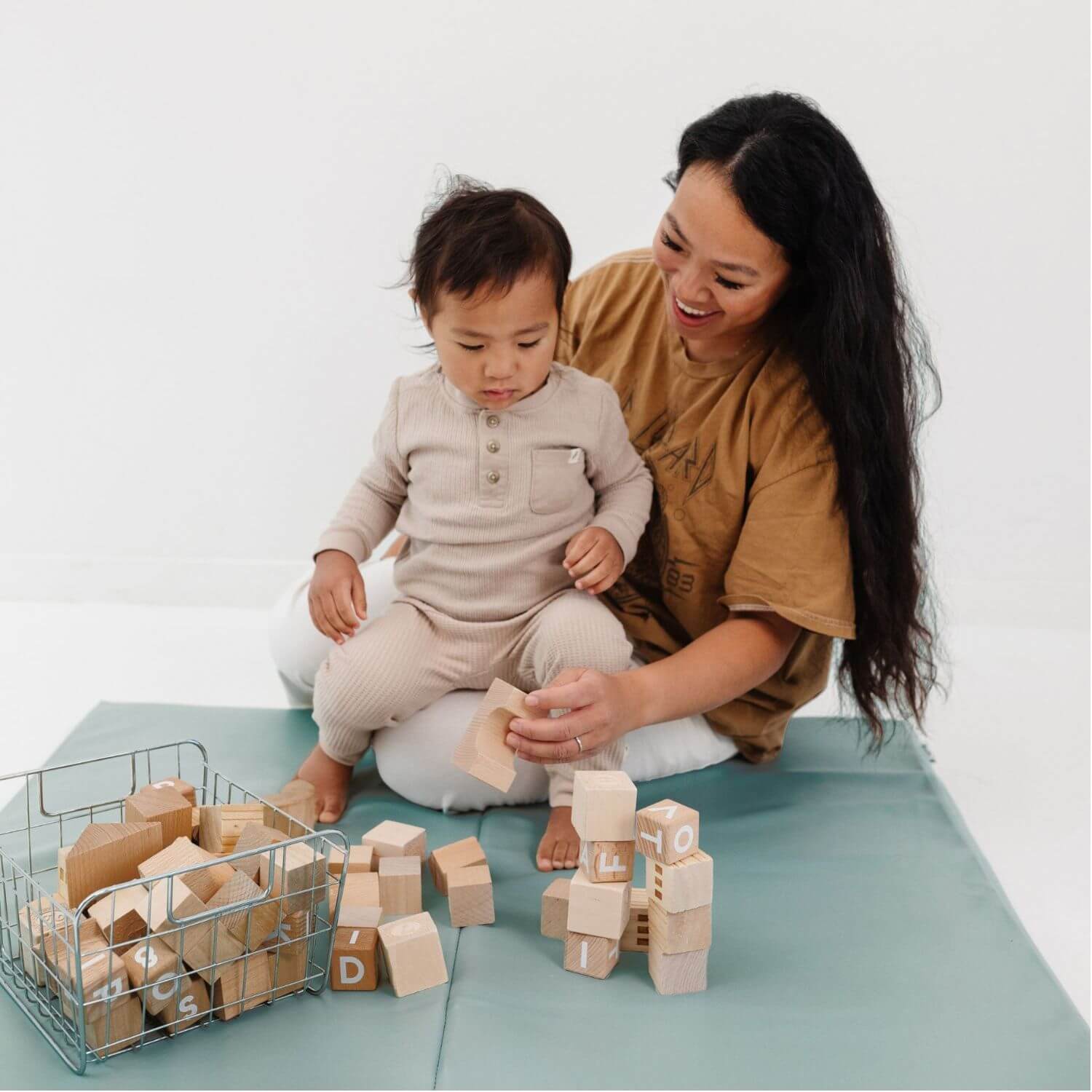 Woman and child playing with wooden blocks on Toki Kids Sage Vegan Leather Mat