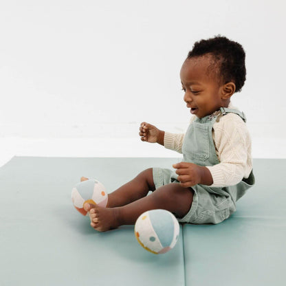 Child sitting on Toki Kids Sage Vegan Leather Mat