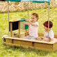 Two children playing in Hape Sandbox Cabana Kit on a grassy area.
