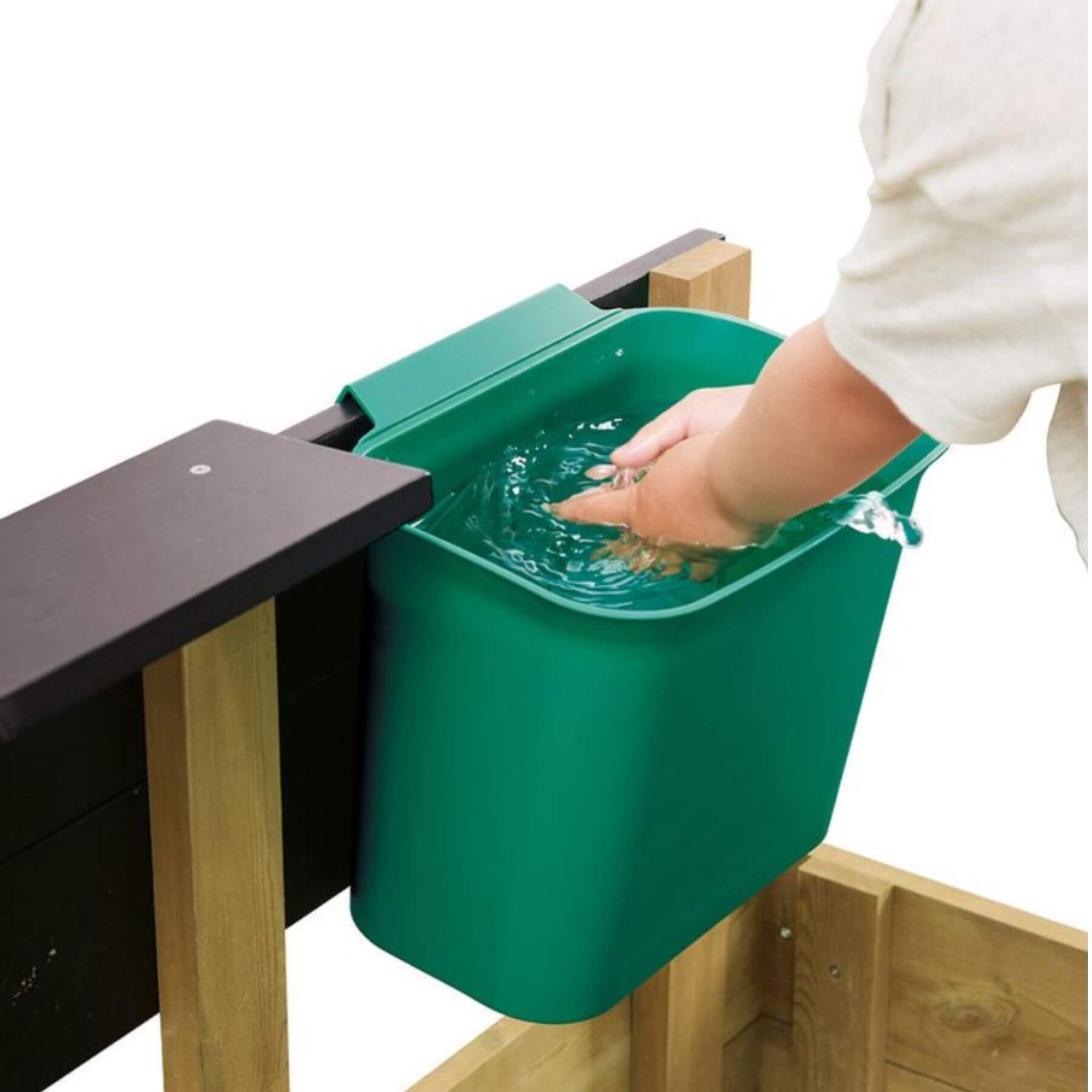 Green compost bin attached to a wooden table with a hand reaching in.