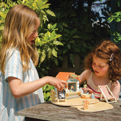 Two children playing with Tender Leaf Sandy's Beach Hut outdoors.