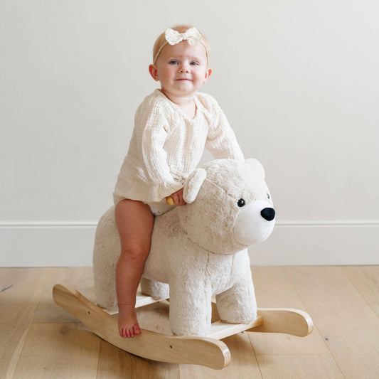 Child sitting on Saranoni Stuffed Animal Rocker Bear indoors.