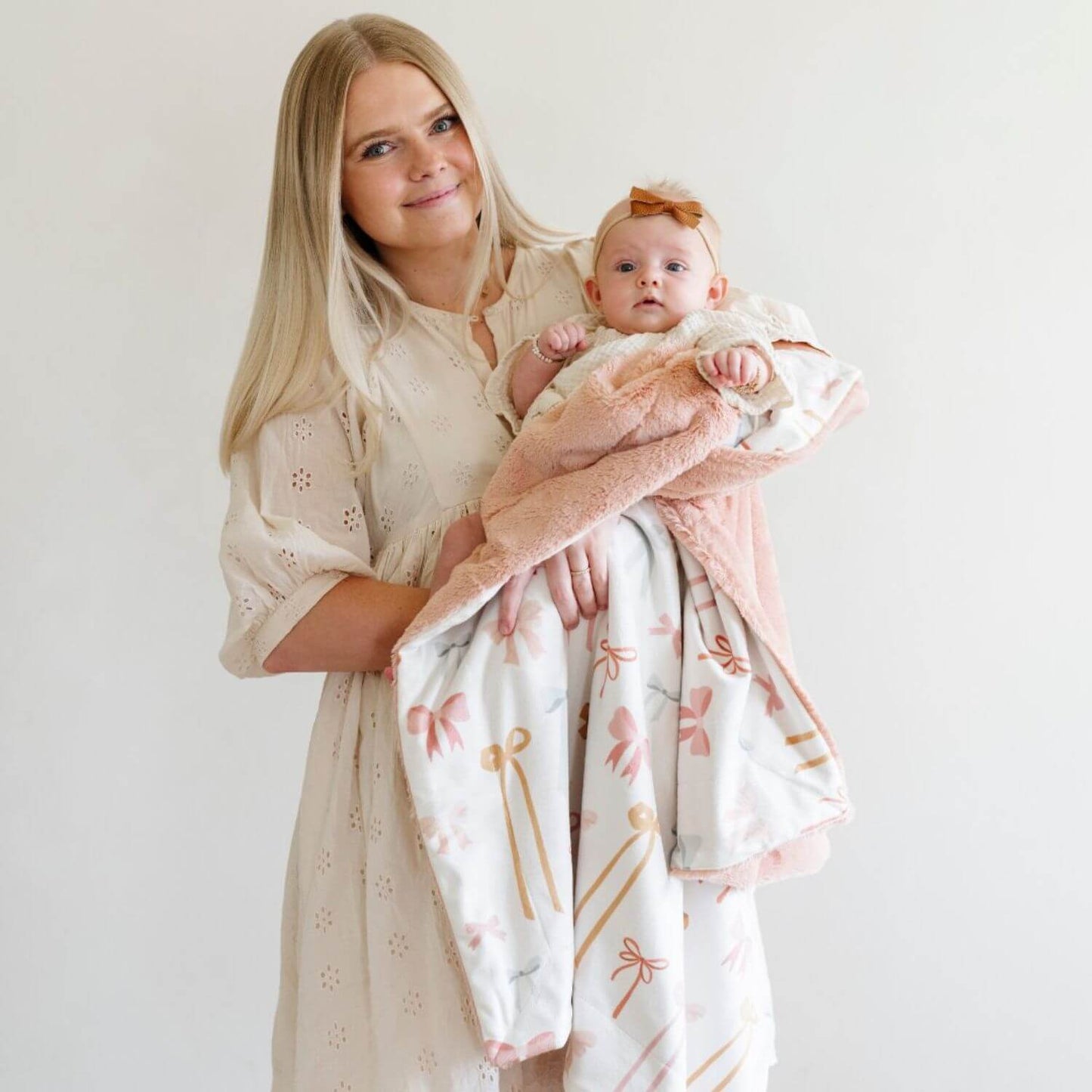 Woman holding a baby wrapped with Saranoni Minky/Lush Receiving Blanket