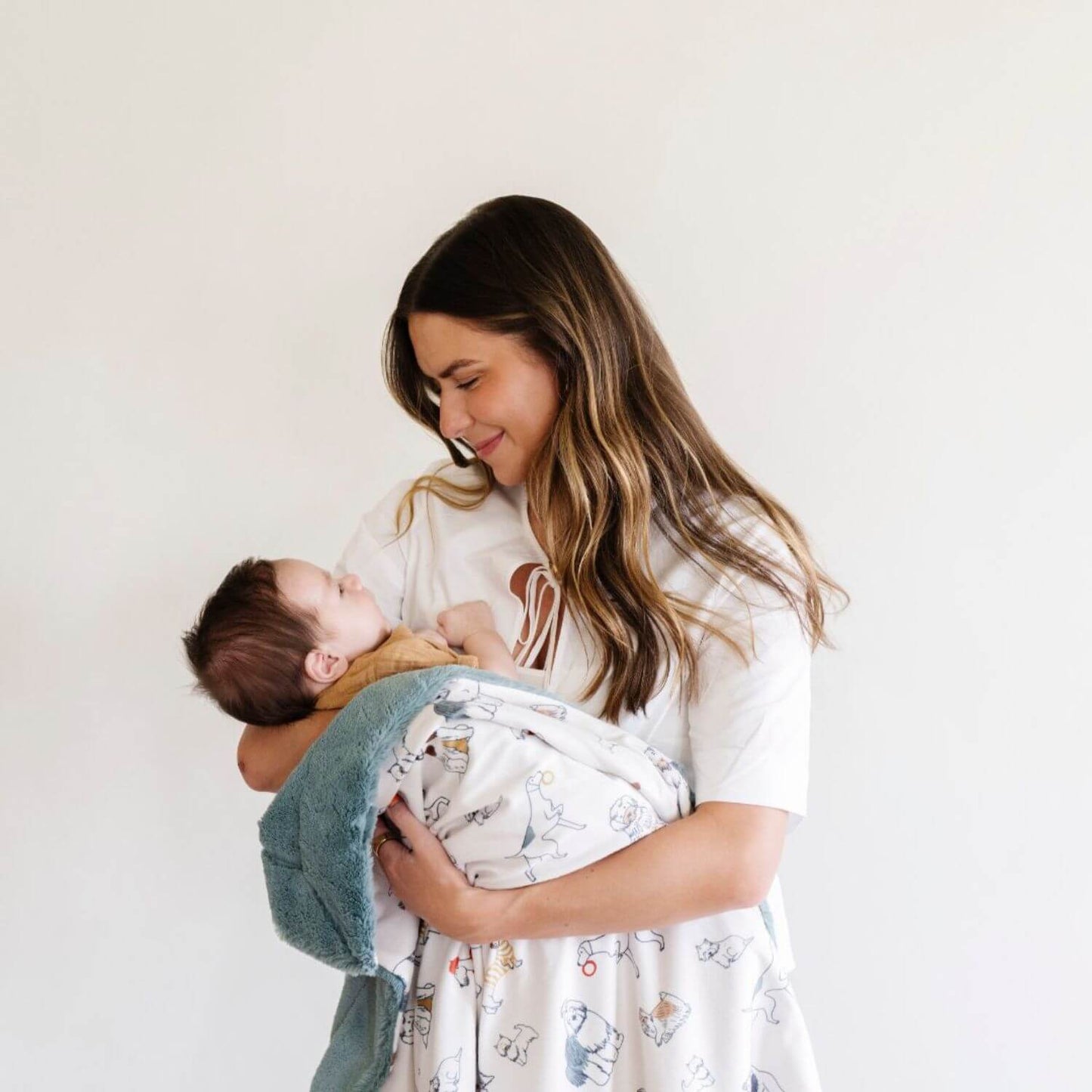 Woman holding a baby wrapped with Saranoni Minky/Lush Receiving Blanket Dog