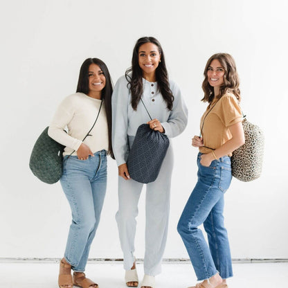 Three women holding bags against a white background