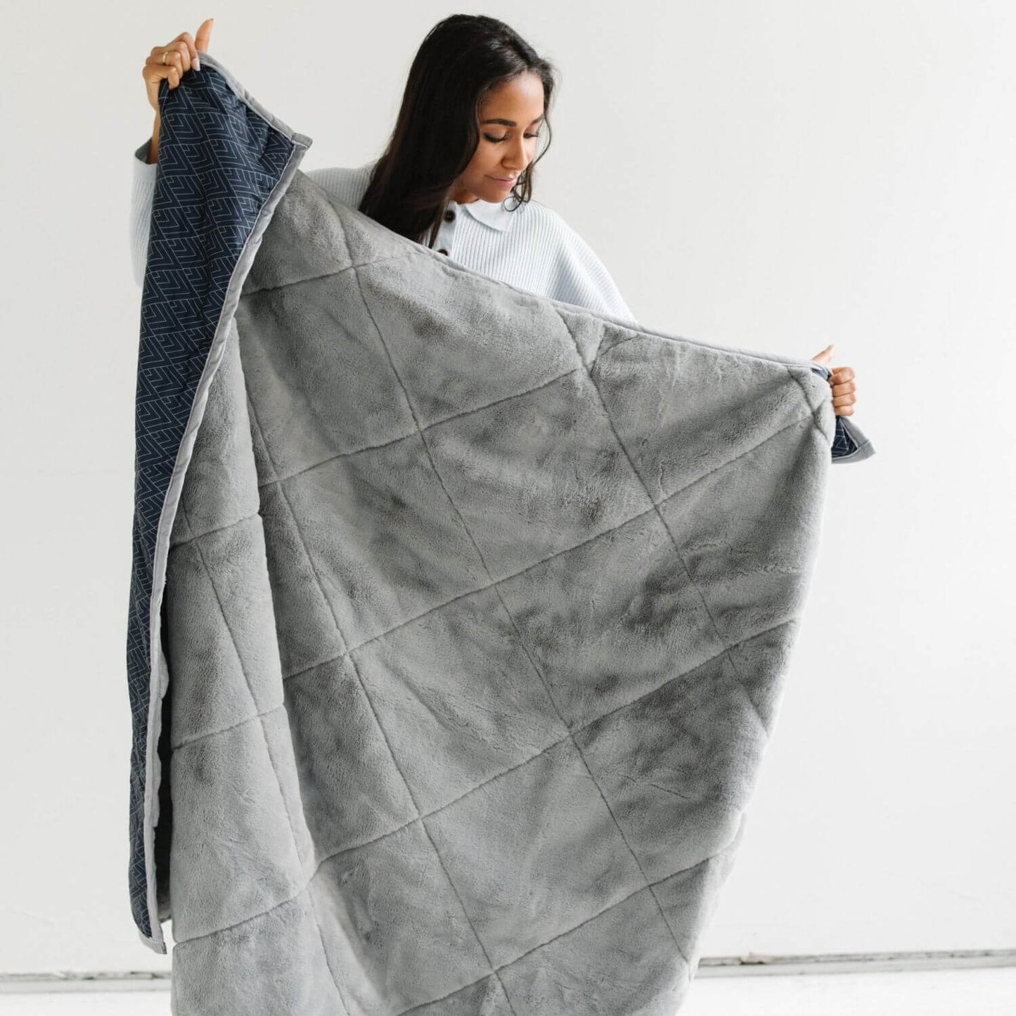 Woman holding Saranoni Outdoor Blanket against a white background