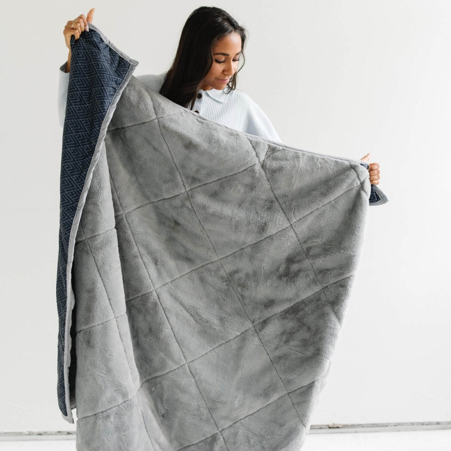 Woman holding Saranoni Outdoor Blanket against a white background